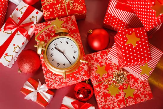 Clock sitting on top of a pile of wrapped gifts