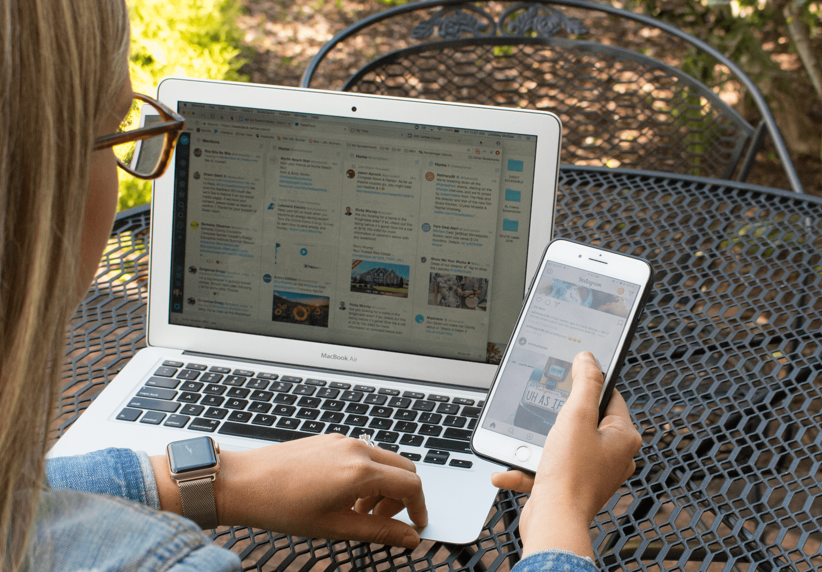 Woman using laptop and phone simultaneously