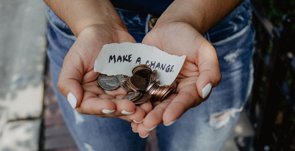 Woman holding change with a note saying, 