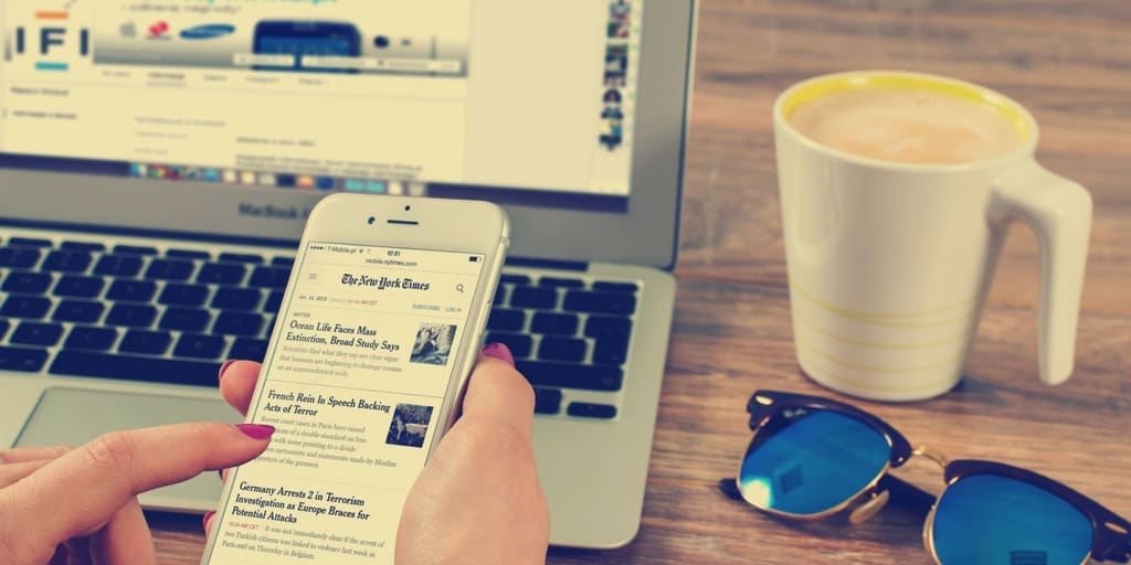 Person scrolling through news on their phone