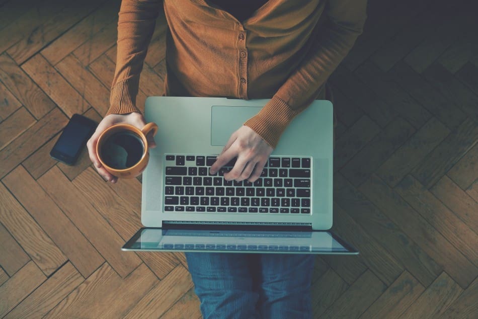 Person sitting on the floor, using their laptop