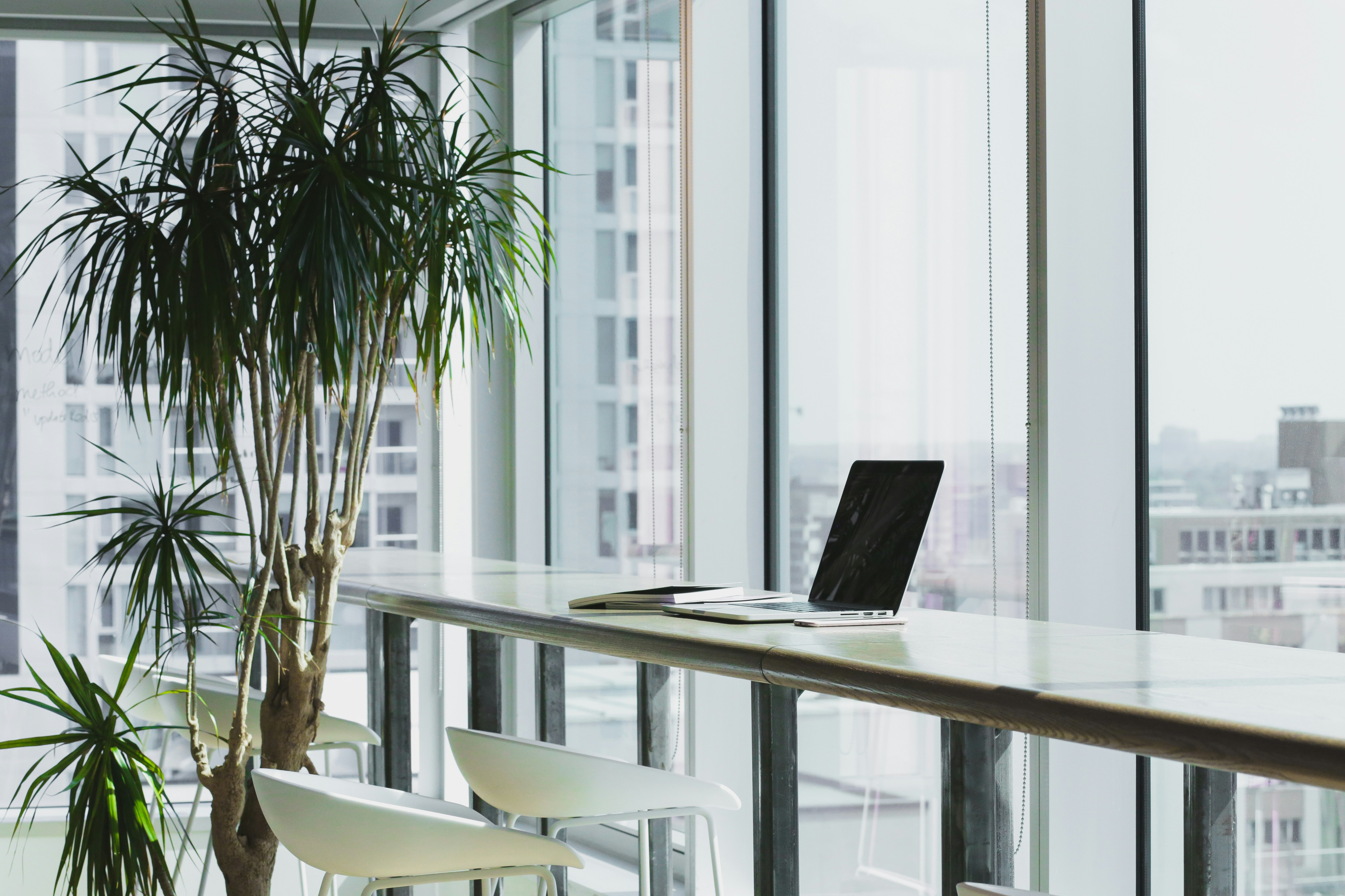 Modern office with glass windows, laptop on table