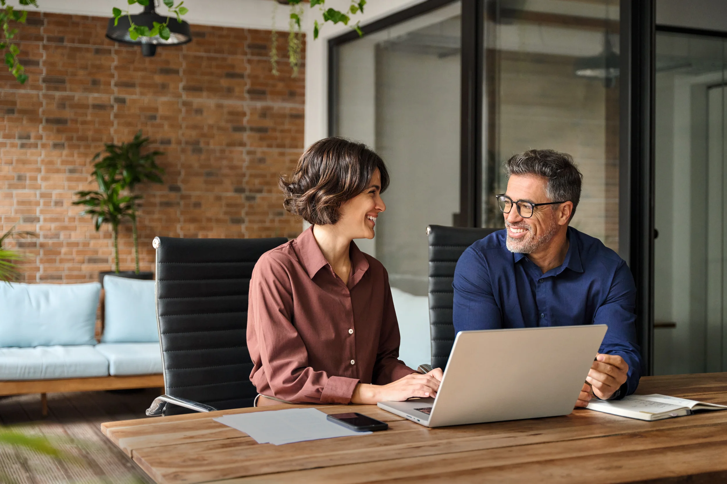 Man and woman smiling at laptop