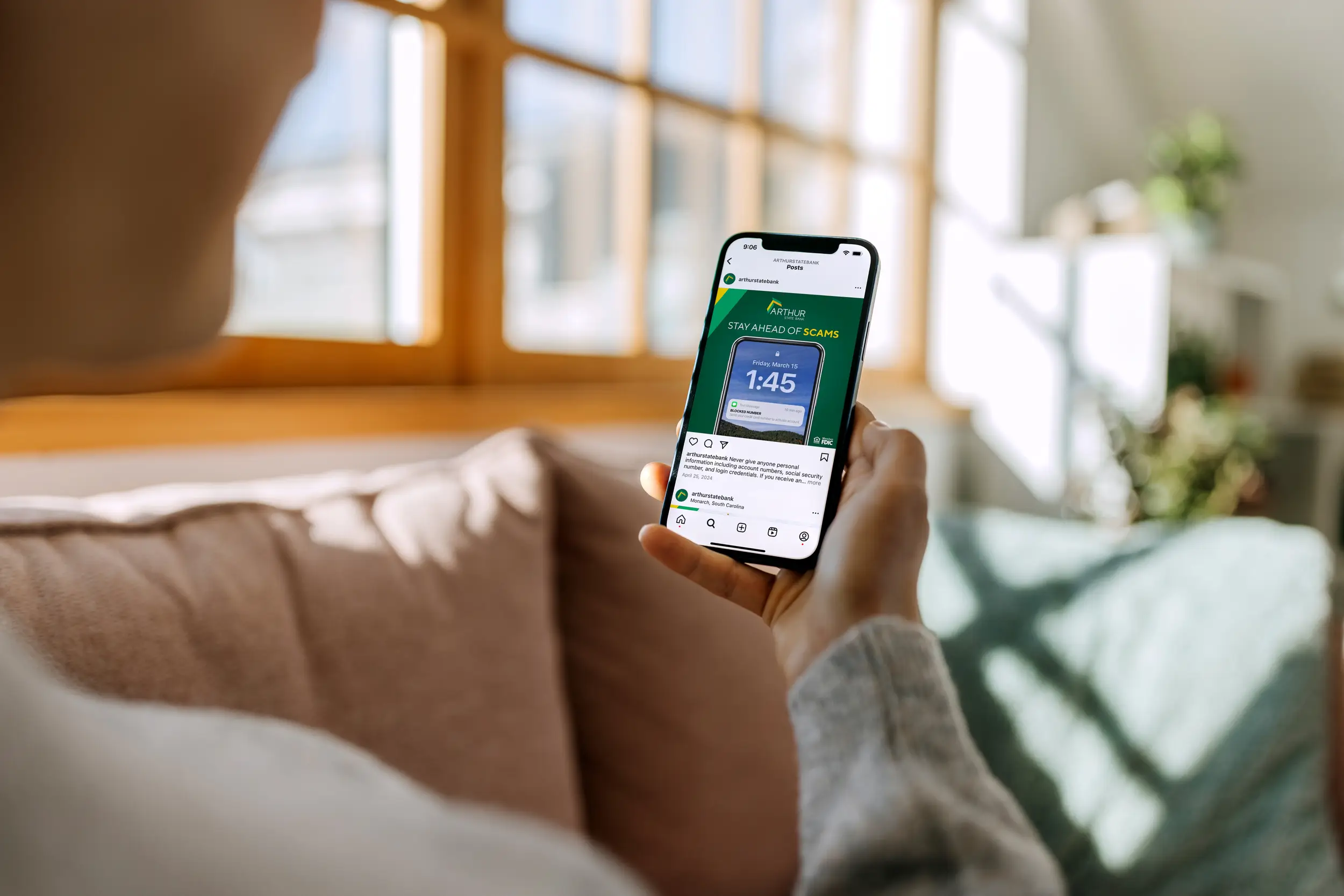 holding phone with arthur state bank ad