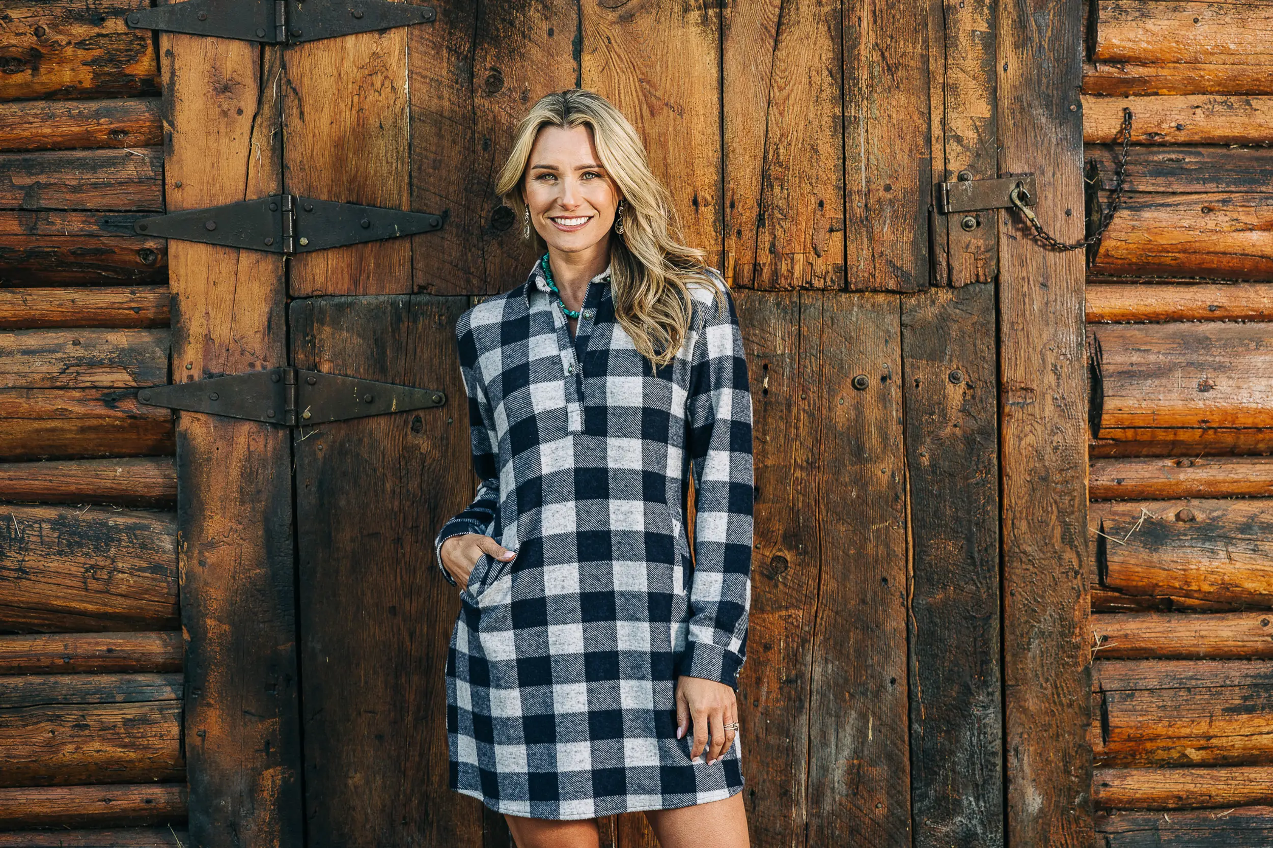 girl in plaid dress in front of barn