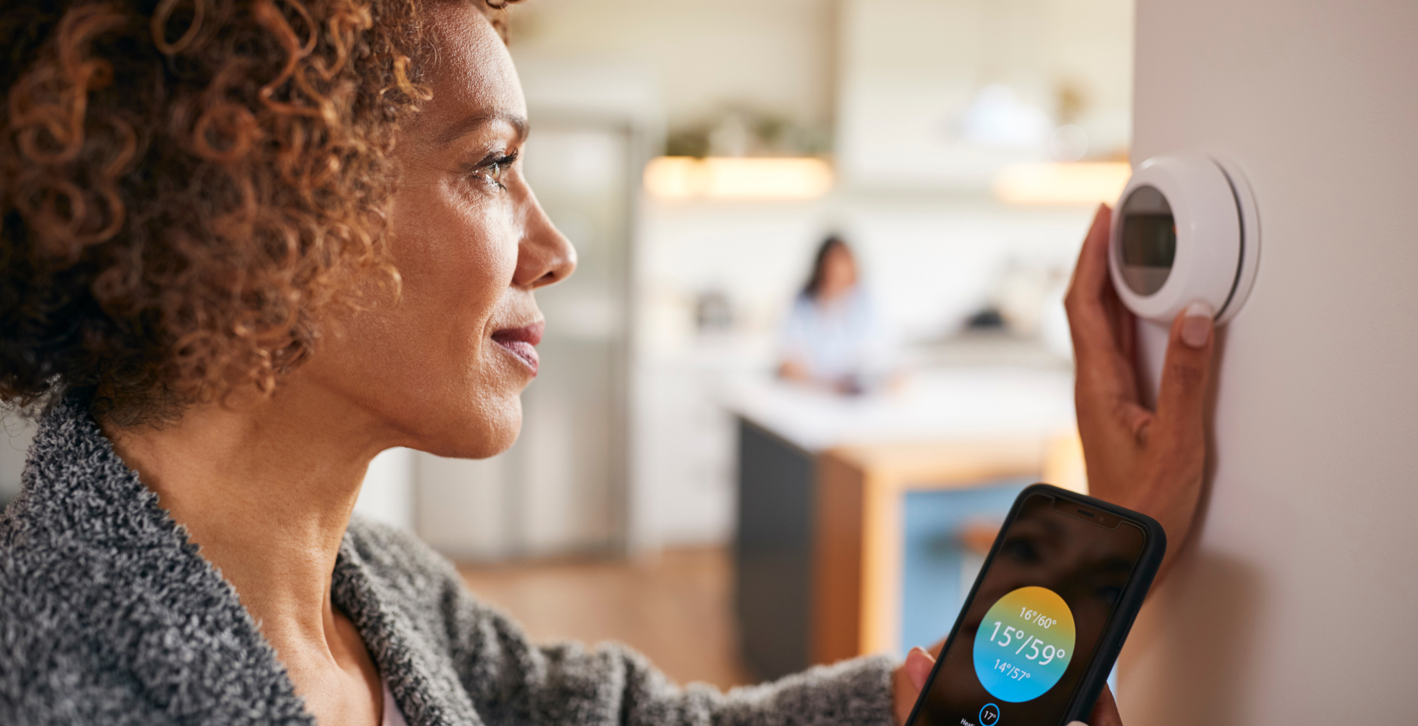 Lady adjusting thermostat