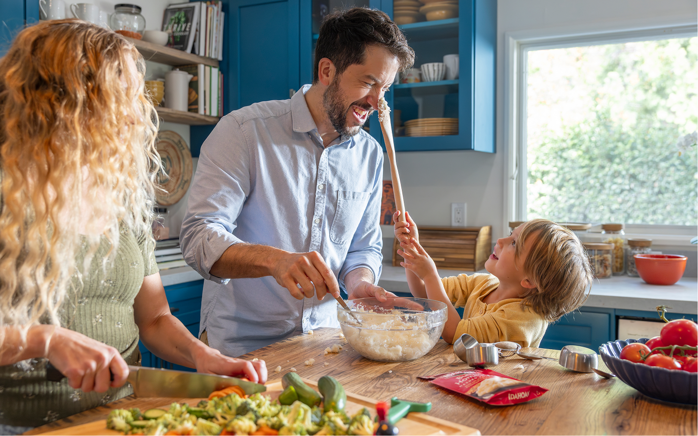 Family in kitchen making potatoes